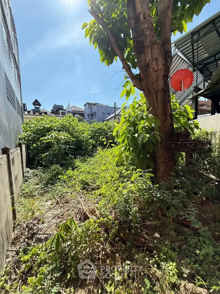 Vacant land with lush greenery and urban surroundings, ideal for development opportunities.