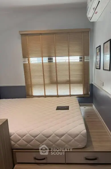 Cozy bedroom with modern design featuring a built-in bed and window blinds.