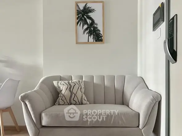 Stylish living room with modern sofa and palm tree artwork, perfect for cozy relaxation.
