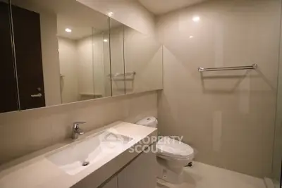 Modern bathroom with sleek fixtures and large mirror in a contemporary home.