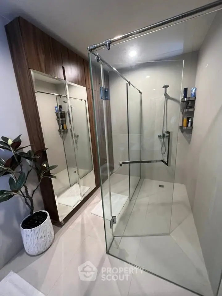 Modern bathroom with glass shower enclosure and stylish wooden cabinet