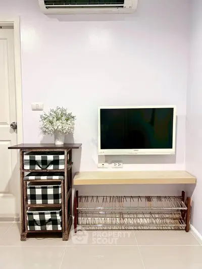 Charming interior with wall-mounted TV, air conditioning, and stylish storage solutions.