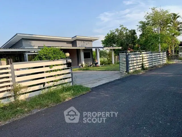 Modern single-story house with spacious driveway and lush greenery