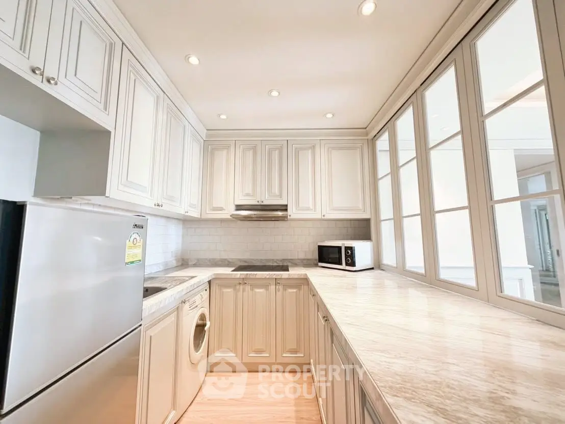 Elegant kitchen with white cabinetry and modern appliances in a bright, spacious layout.