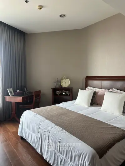Cozy bedroom with elegant wooden furniture and soft lighting, perfect for relaxation and comfort.