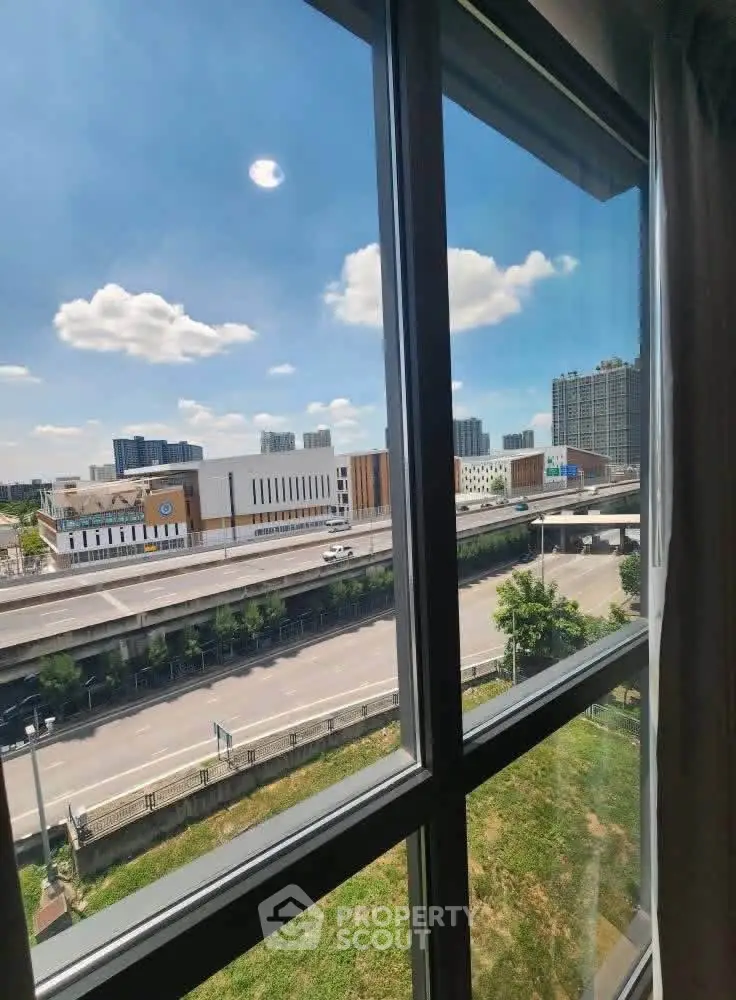 Stunning cityscape view from modern apartment window with clear blue sky.