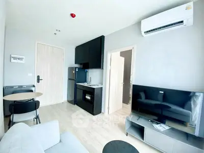 Modern living room with compact kitchen and sleek furniture in a cozy apartment.