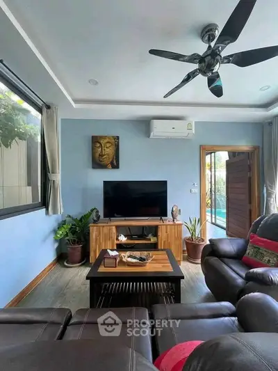 Stylish living room with modern decor, leather sofas, and pool view, perfect for relaxation and entertainment.
