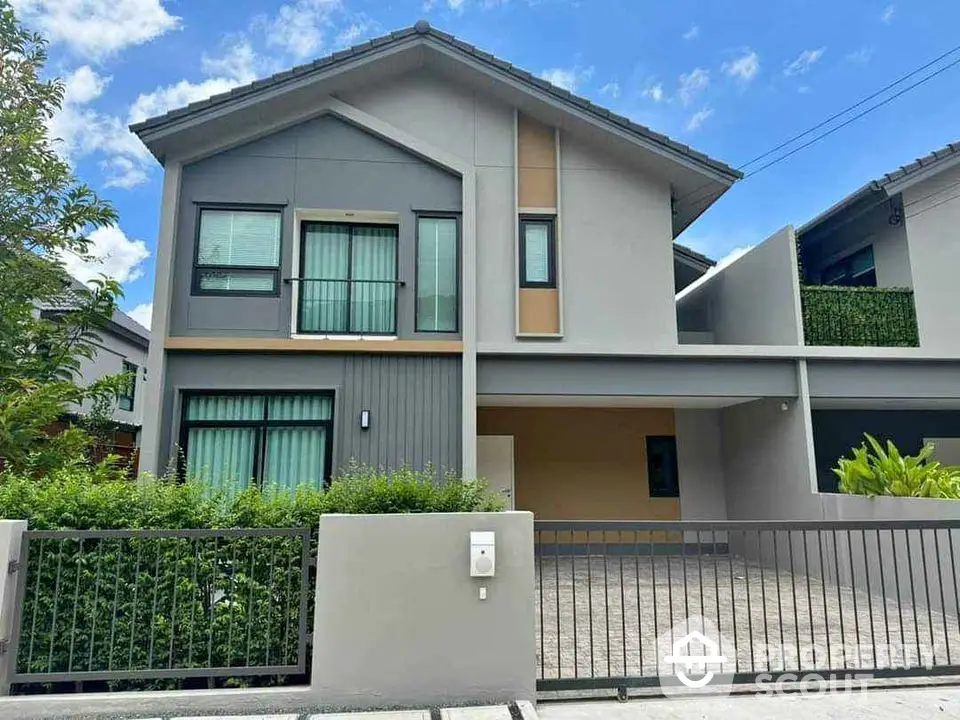 Modern two-story house with sleek design and spacious driveway in suburban neighborhood.