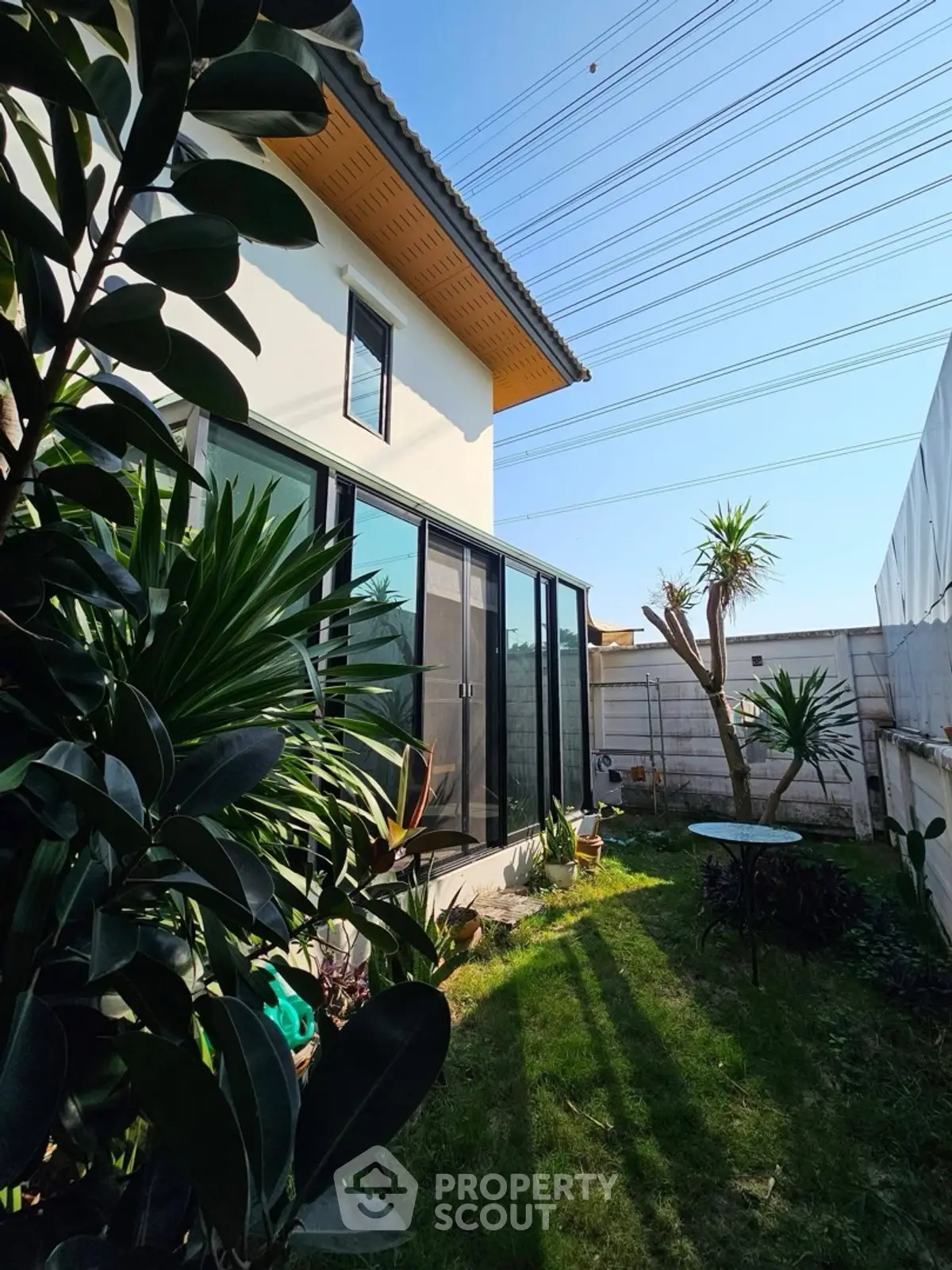 Charming modern home with lush garden and large glass doors, perfect for nature lovers seeking tranquility.