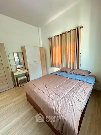 Cozy bedroom with modern furnishings and natural light, perfect for relaxation and comfort.