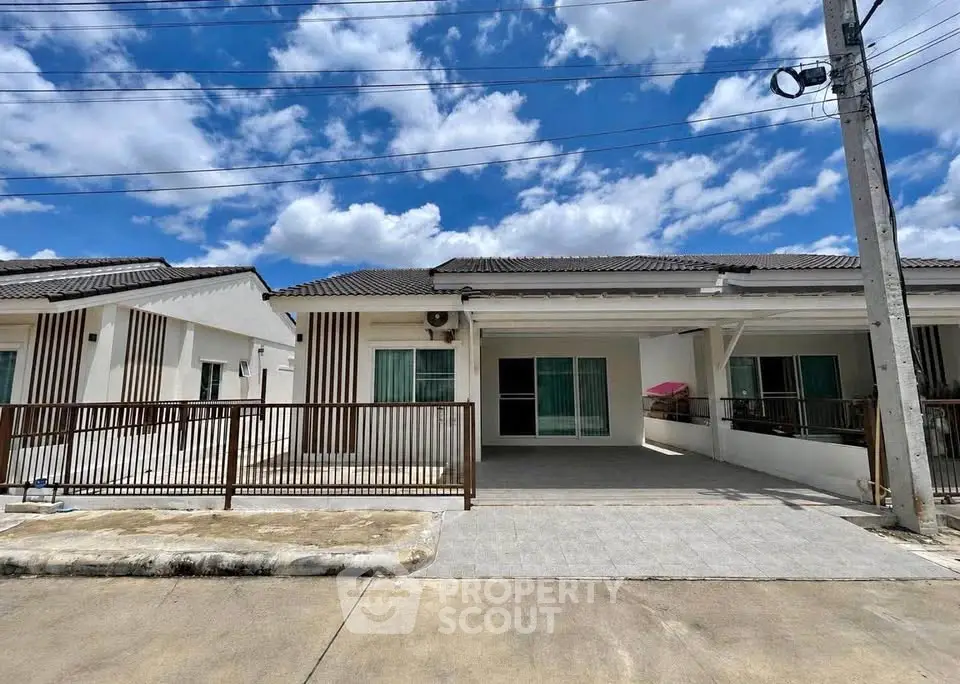 Charming single-story house with modern facade and spacious driveway under a clear blue sky.