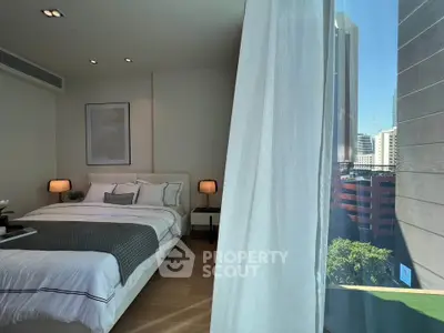 Luxurious bedroom with city view, featuring elegant decor and natural light through large windows.