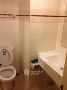 Compact bathroom with modern fixtures and neutral tiles