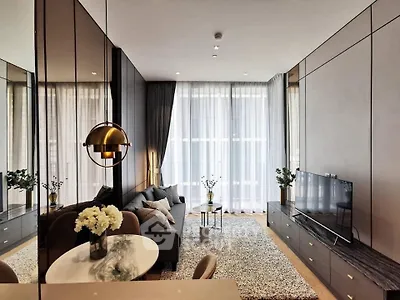 Modern living room with elegant decor and large windows, featuring a cozy seating area and stylish lighting.