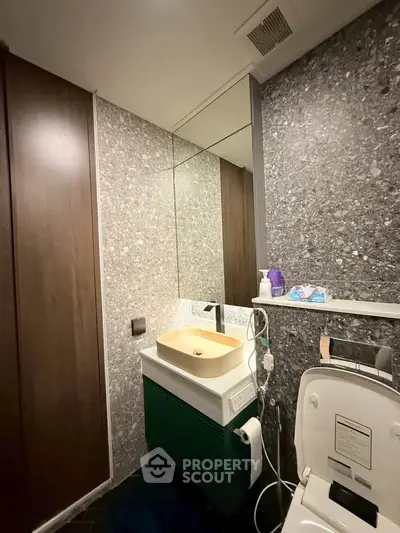 Modern bathroom with stylish sink and toilet, featuring sleek design and contemporary finishes.