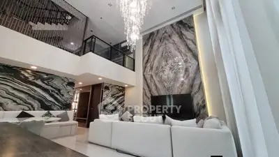 Luxurious modern living room with high ceilings and elegant chandelier