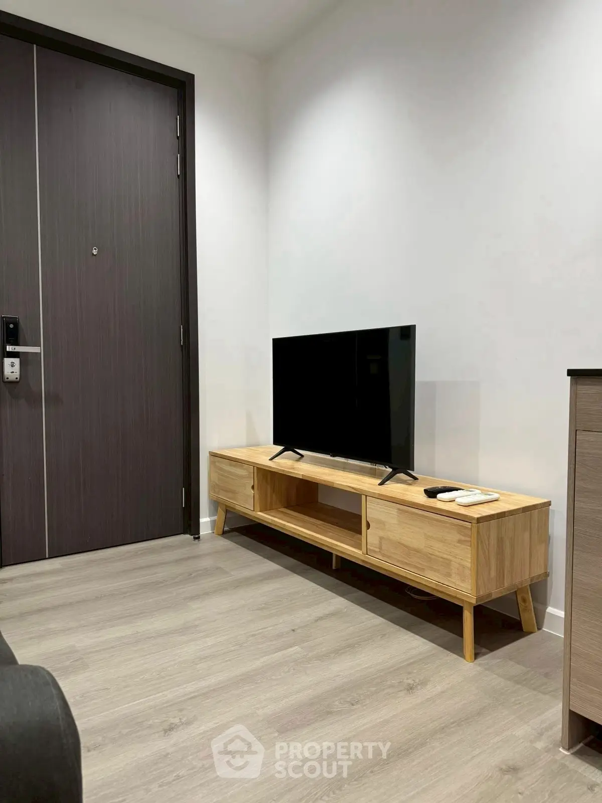 Modern living room corner with sleek TV stand and flat-screen TV.