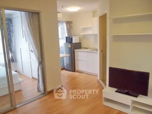 Modern apartment interior with open layout, featuring a cozy living area and compact kitchen.
