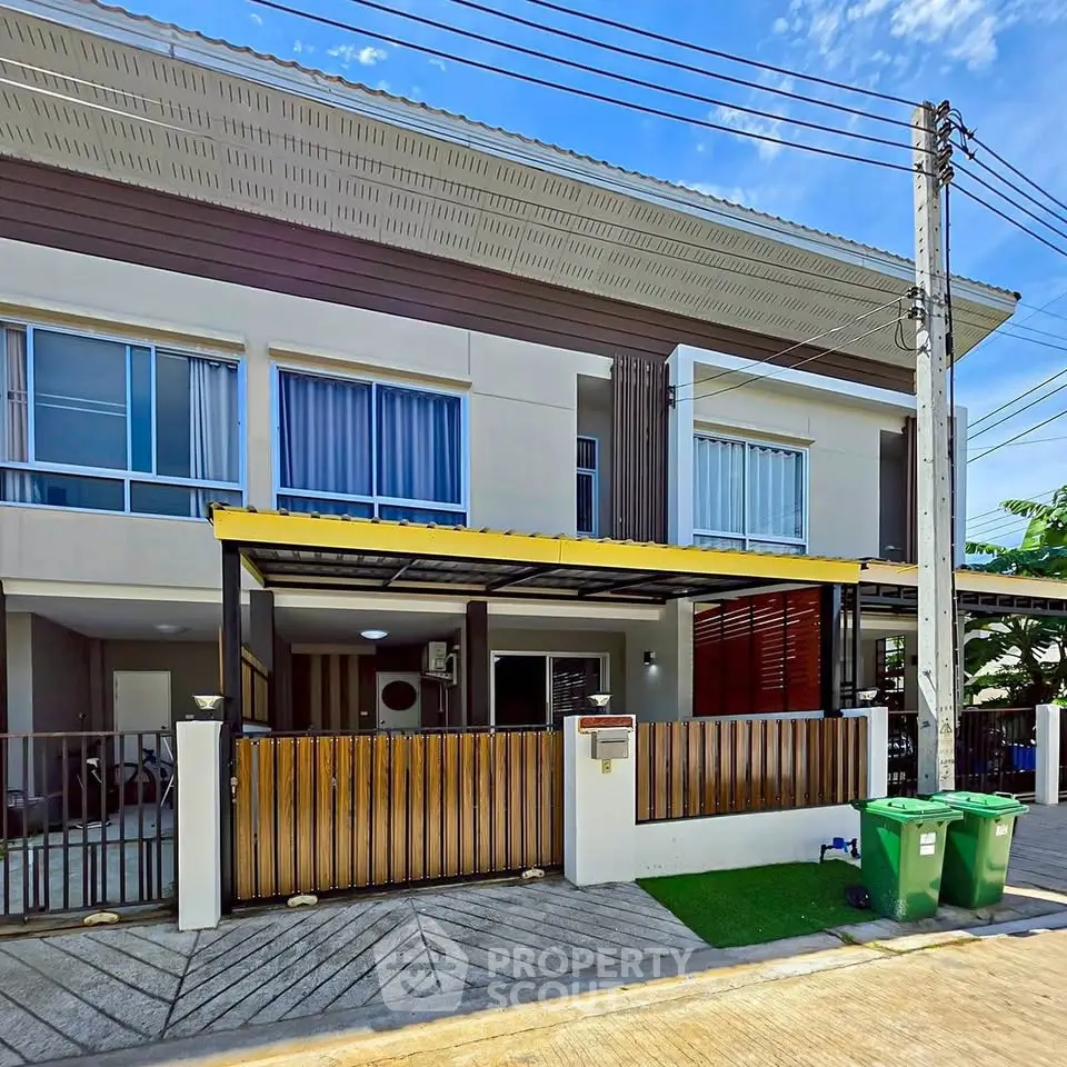 Modern townhouse exterior with gated entrance and driveway in a suburban neighborhood.