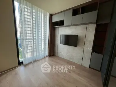 Modern living room with floor-to-ceiling windows and built-in TV unit in a high-rise apartment.