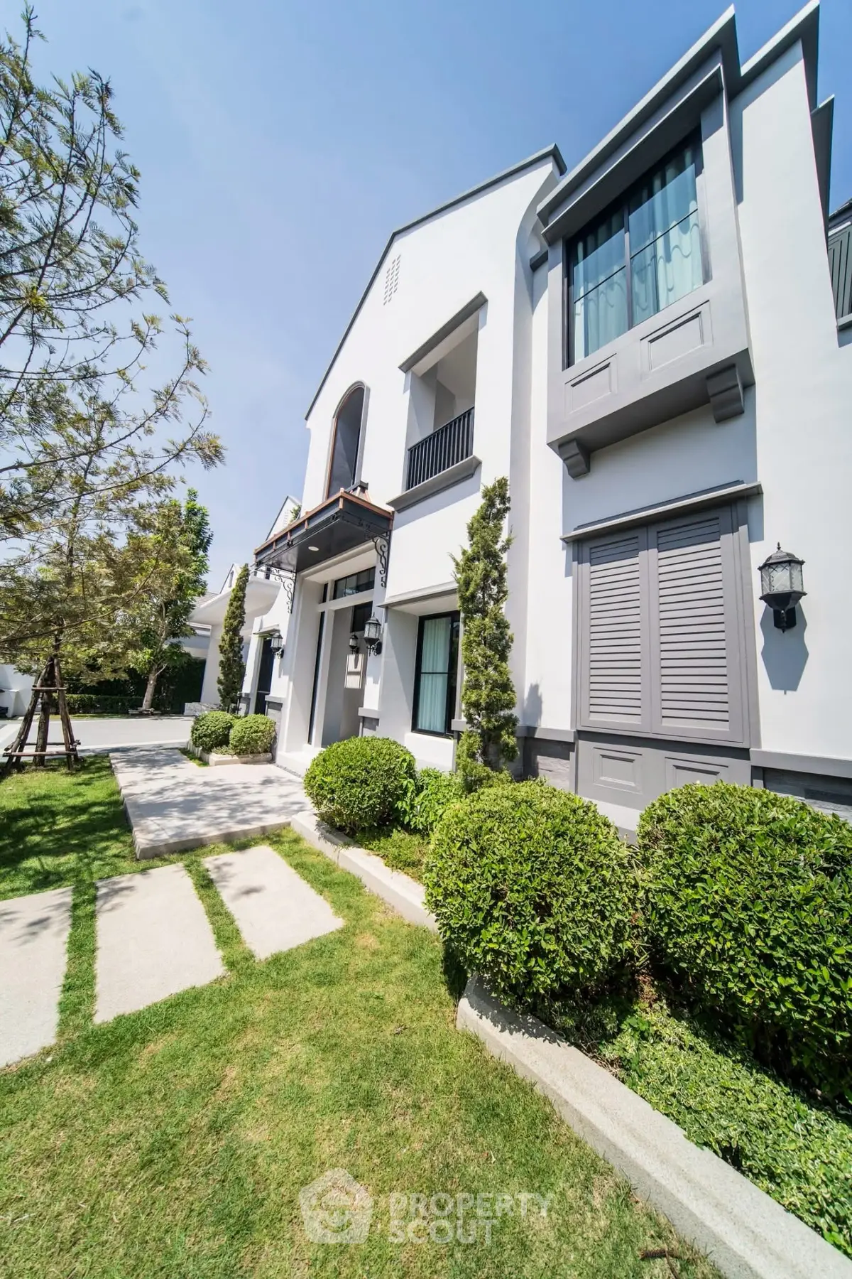 Modern two-story house with lush garden and elegant facade