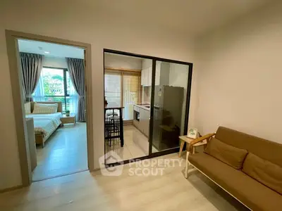 Modern apartment with open layout, featuring cozy living room and sleek kitchen.