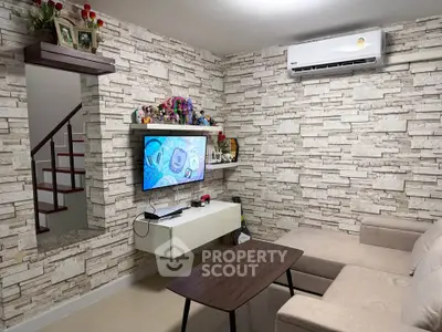 Stylish living room with modern decor and wall-mounted TV, perfect for relaxation and entertainment.