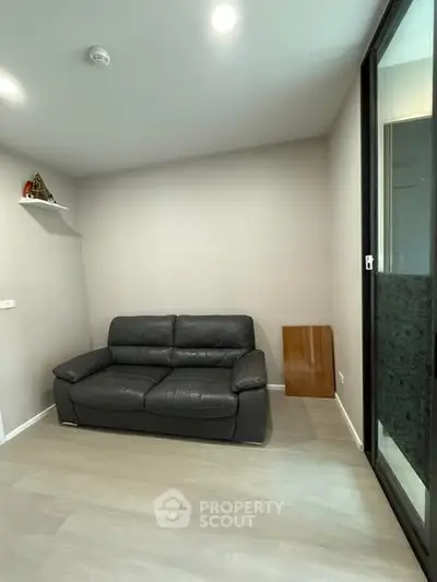 Modern living room with sleek black leather sofa and minimalist decor