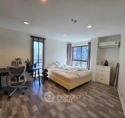 Spacious bedroom with modern decor and city view, ideal for urban living.