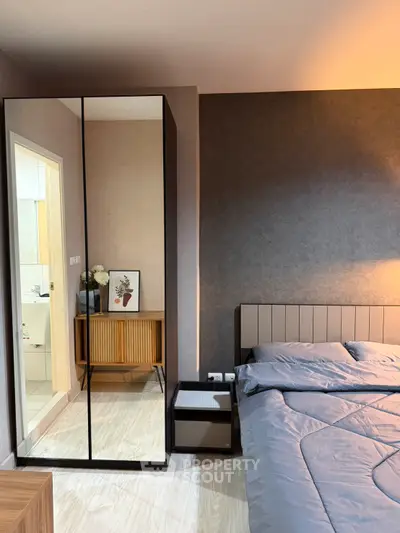 Modern bedroom with stylish decor and mirrored wardrobe