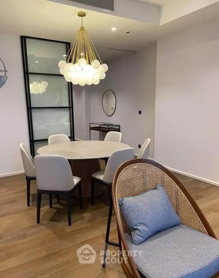 Modern dining area with elegant chandelier and stylish furniture in a contemporary apartment.