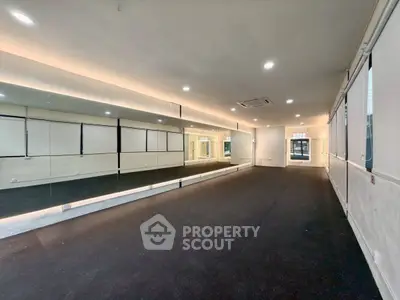 Spacious interior with mirrored wall ideal for dance studio or fitness space.