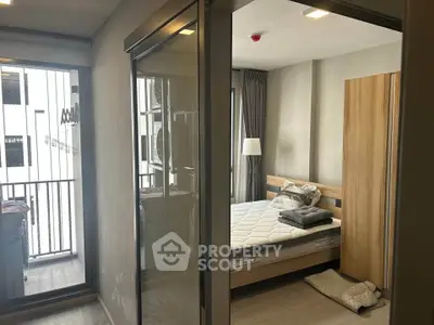 Modern bedroom with sliding glass doors and balcony view in a stylish apartment.