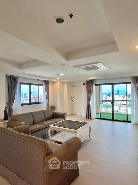Spacious living room with city view and elegant furnishings in modern apartment.