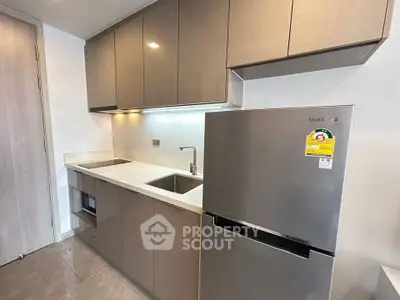 Modern kitchen with sleek cabinetry and stainless steel appliances in a contemporary apartment.