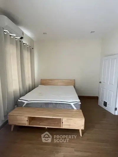 Minimalist bedroom with wooden flooring and modern bed frame