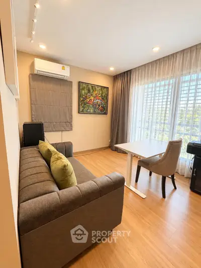 Modern living room with stylish decor, featuring a cozy sofa, elegant table, and large window with natural light.