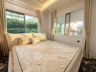 Luxurious bedroom with large windows and elegant bedding in a serene setting.