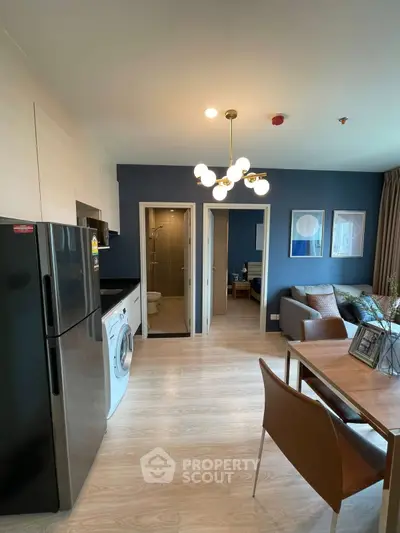 Modern apartment interior with open kitchen, stylish living area, and contemporary lighting.