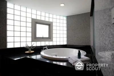 Luxurious bathroom with modern round bathtub and elegant granite finishes.