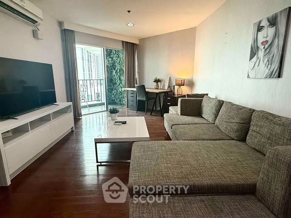 Spacious living room with modern decor and large TV, perfect for relaxation.