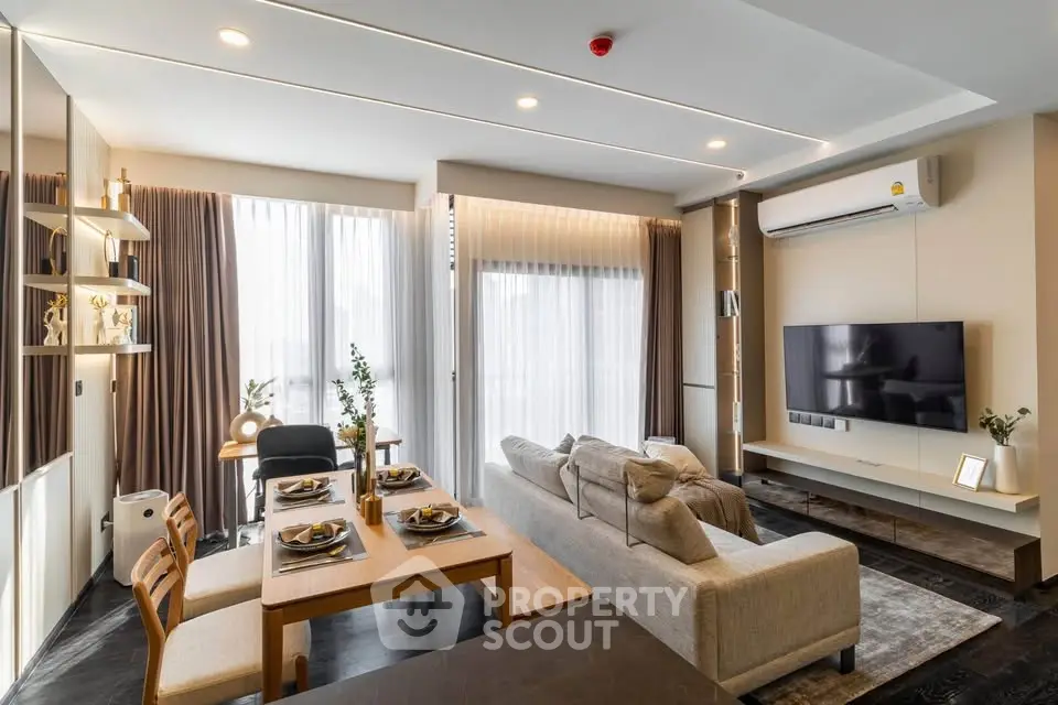 Modern living room with stylish decor, large windows, and open dining area in a contemporary apartment.