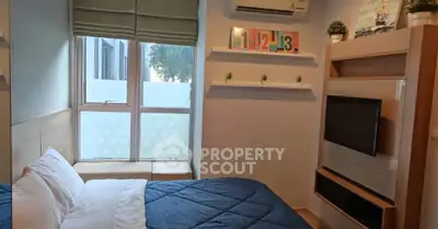 Cozy bedroom with modern decor and large window for natural light.