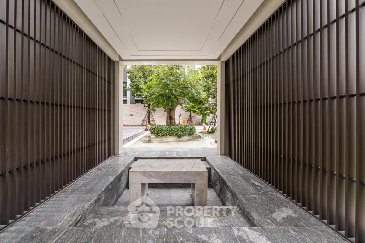 Elegant building entrance with modern design and lush greenery