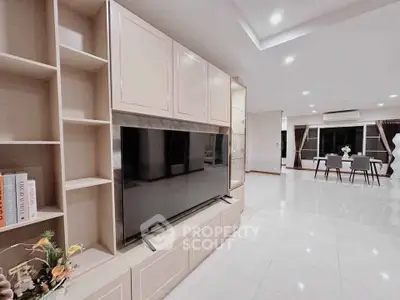 Spacious modern living room with sleek TV unit and elegant dining area, perfect for family gatherings.