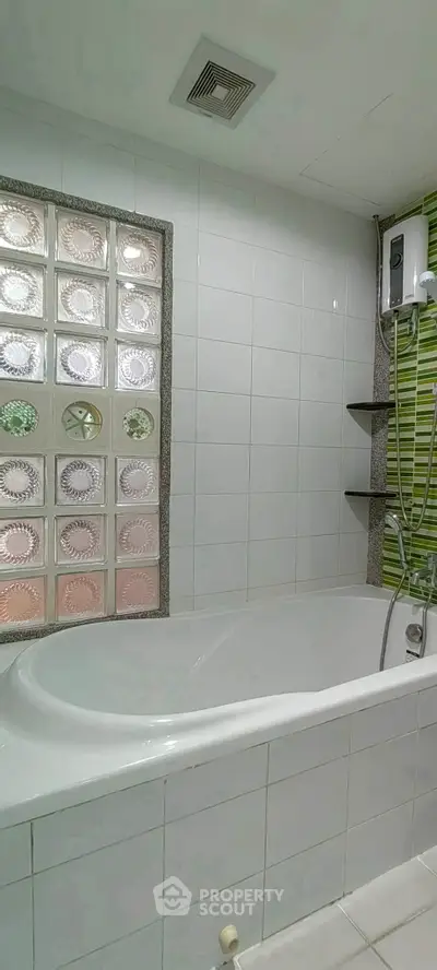 Modern bathroom with stylish bathtub and glass block wall accent