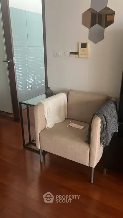 Cozy corner with modern armchair and side table in stylish apartment