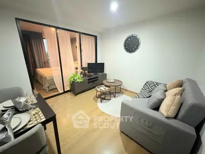 Modern living room with cozy seating and stylish decor adjacent to a bedroom.