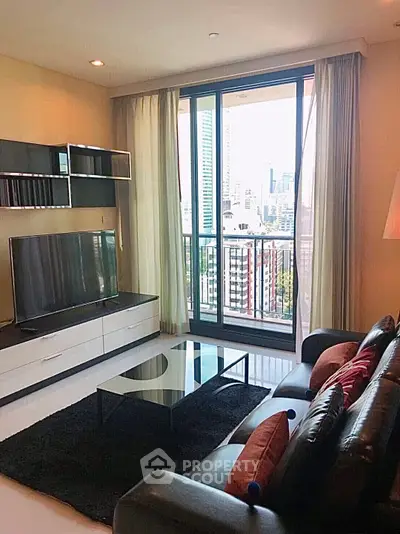Modern living room with city view, sleek furniture, and large windows for natural light.